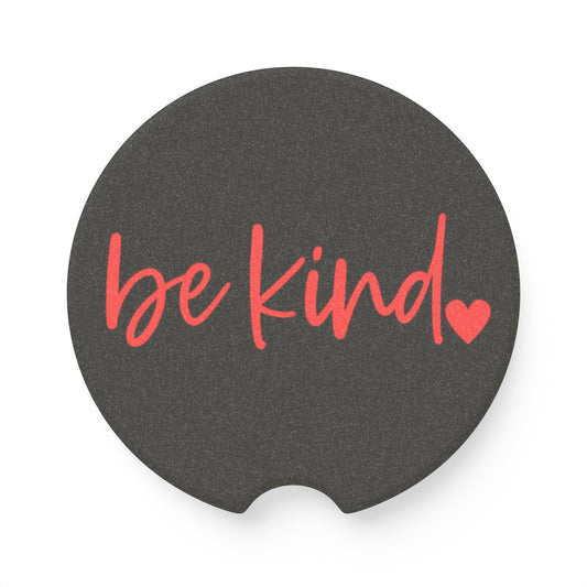Black car coaster with 'be kind' text and heart symbol on a white background
