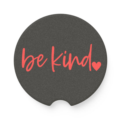 Black car coaster with 'be kind' text and heart symbol on a white background