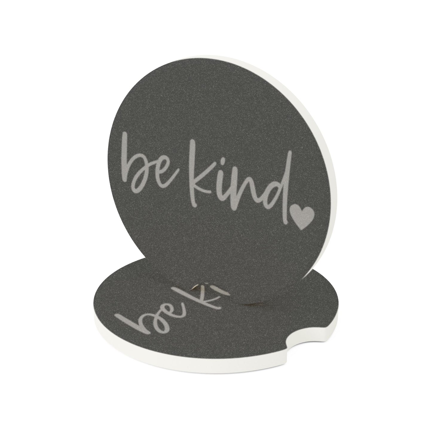 Black coaster with 'be kind' text on a white background