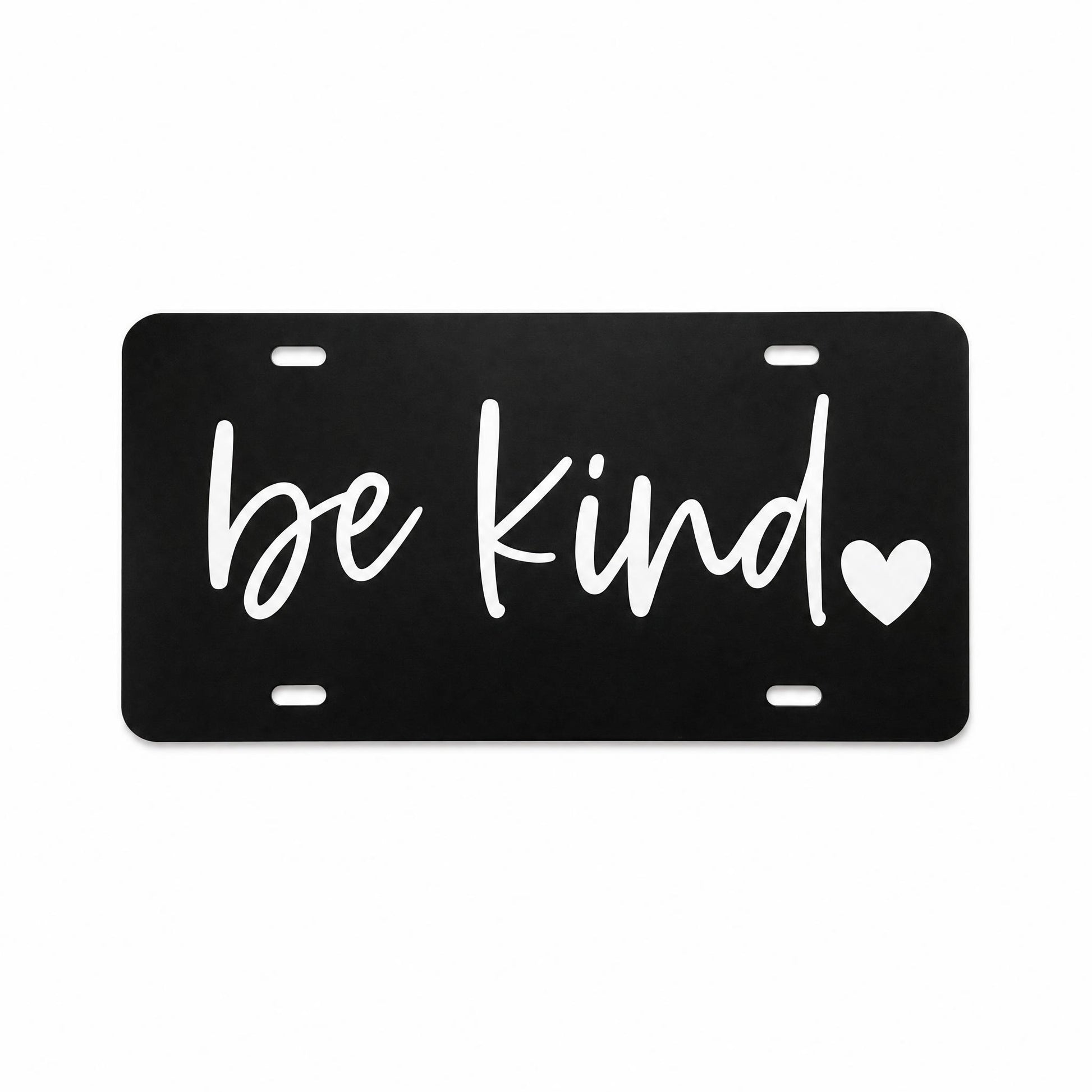Black Be Kind plastic license plate with white script lettering and heart detail on light background