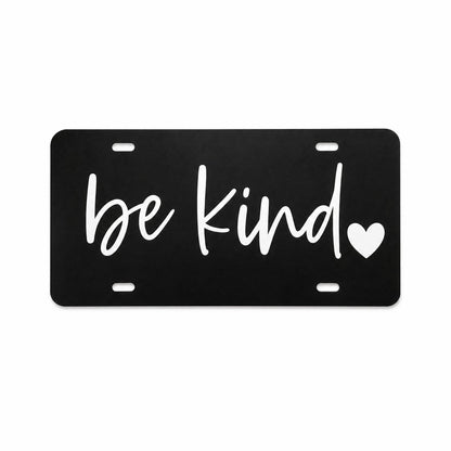 Black Be Kind plastic license plate with white script lettering and heart detail on light background