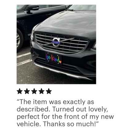 black be kind front license plate in rainbow on a black Volvo
