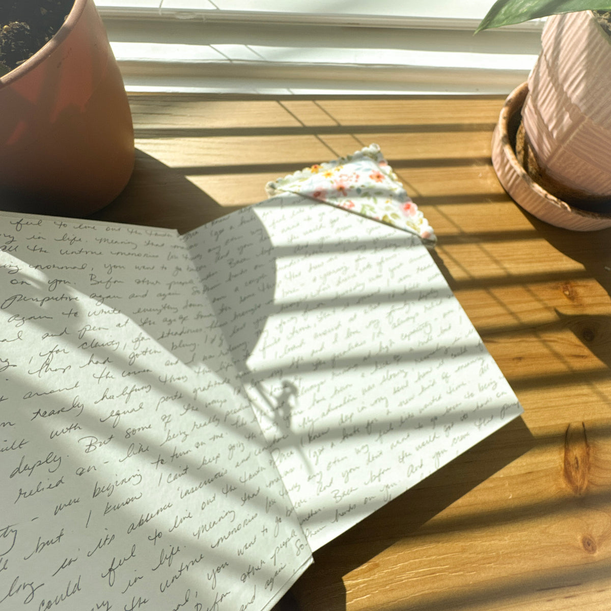 Fabric corner bookmark on an open book in a cozy reading setting
