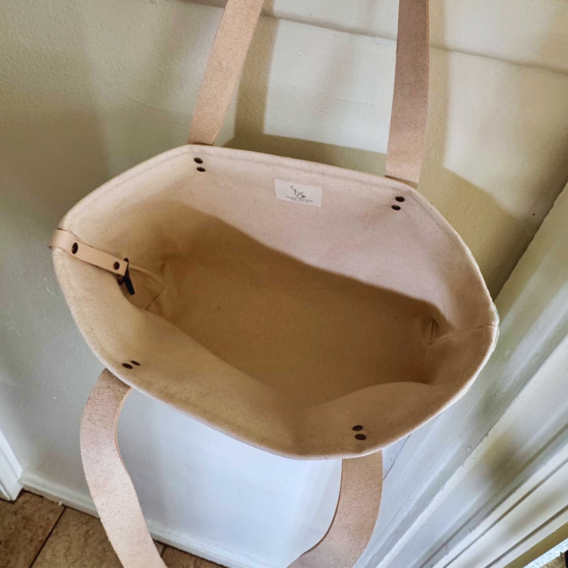 Open interior of a one-of-a-kind botanical tote featuring a durable cotton duck lining, leather key keeper, and Dani Denise Design label.