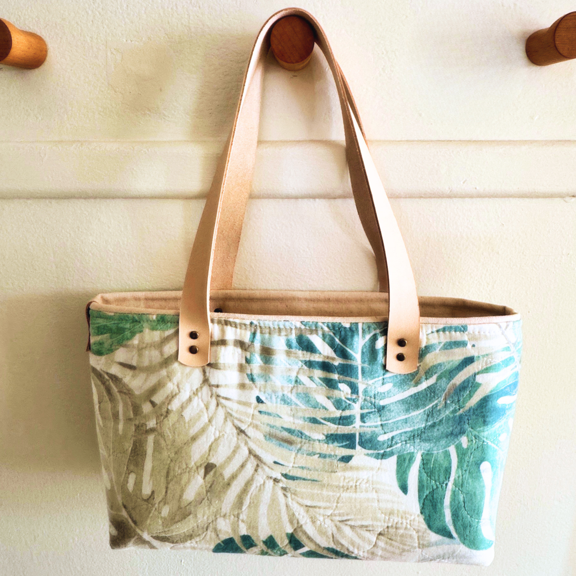 One-of-a-kind botanical tote handcrafted in Southern Indiana from a rescued quilted textile with natural vegetable-tanned leather handles.