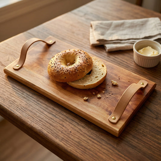 Sycamore serving tray with leather handles holding a bagel on a rustic wood table