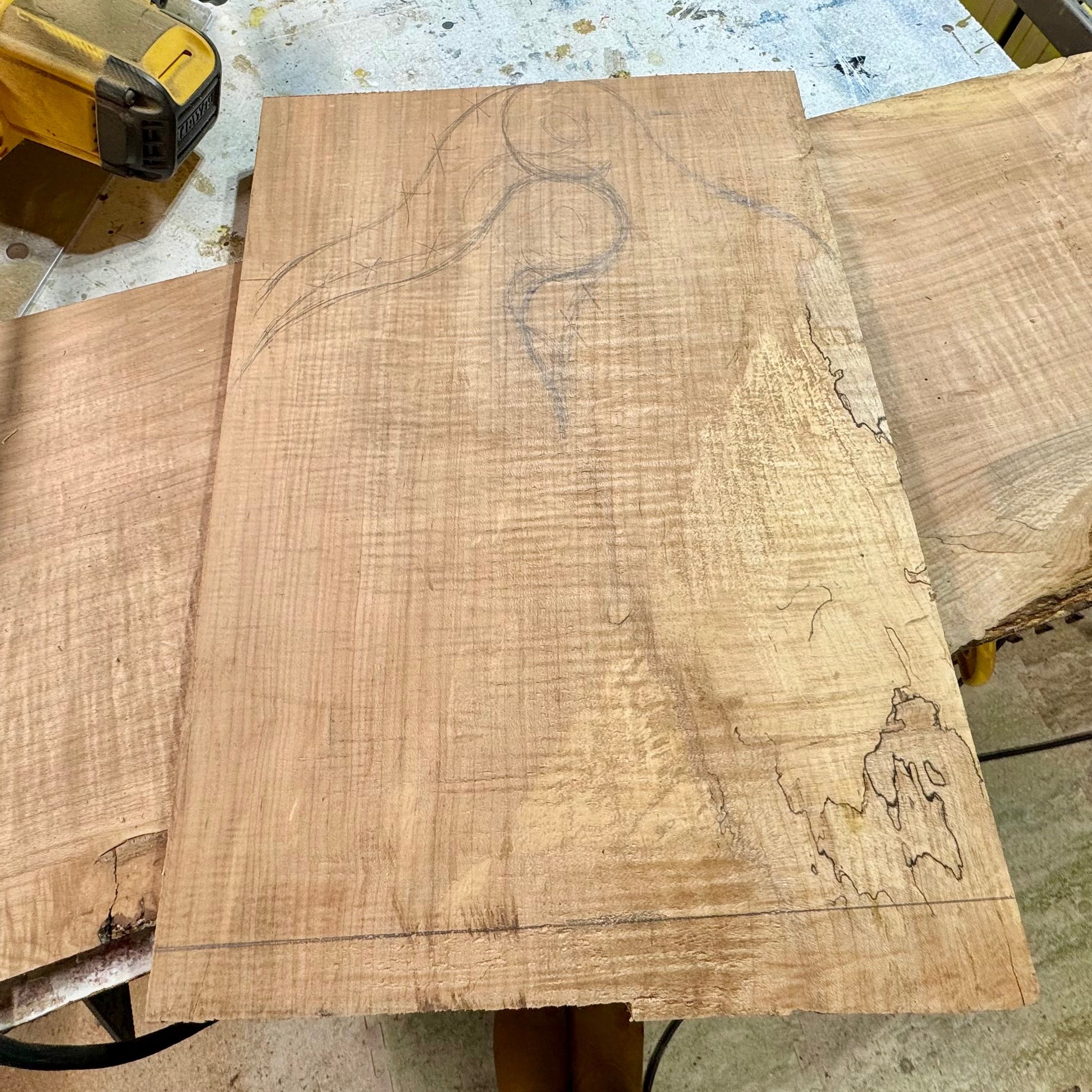 Pencil layout drawn on a walnut slab before cutting a handmade charcuterie board in the workshop